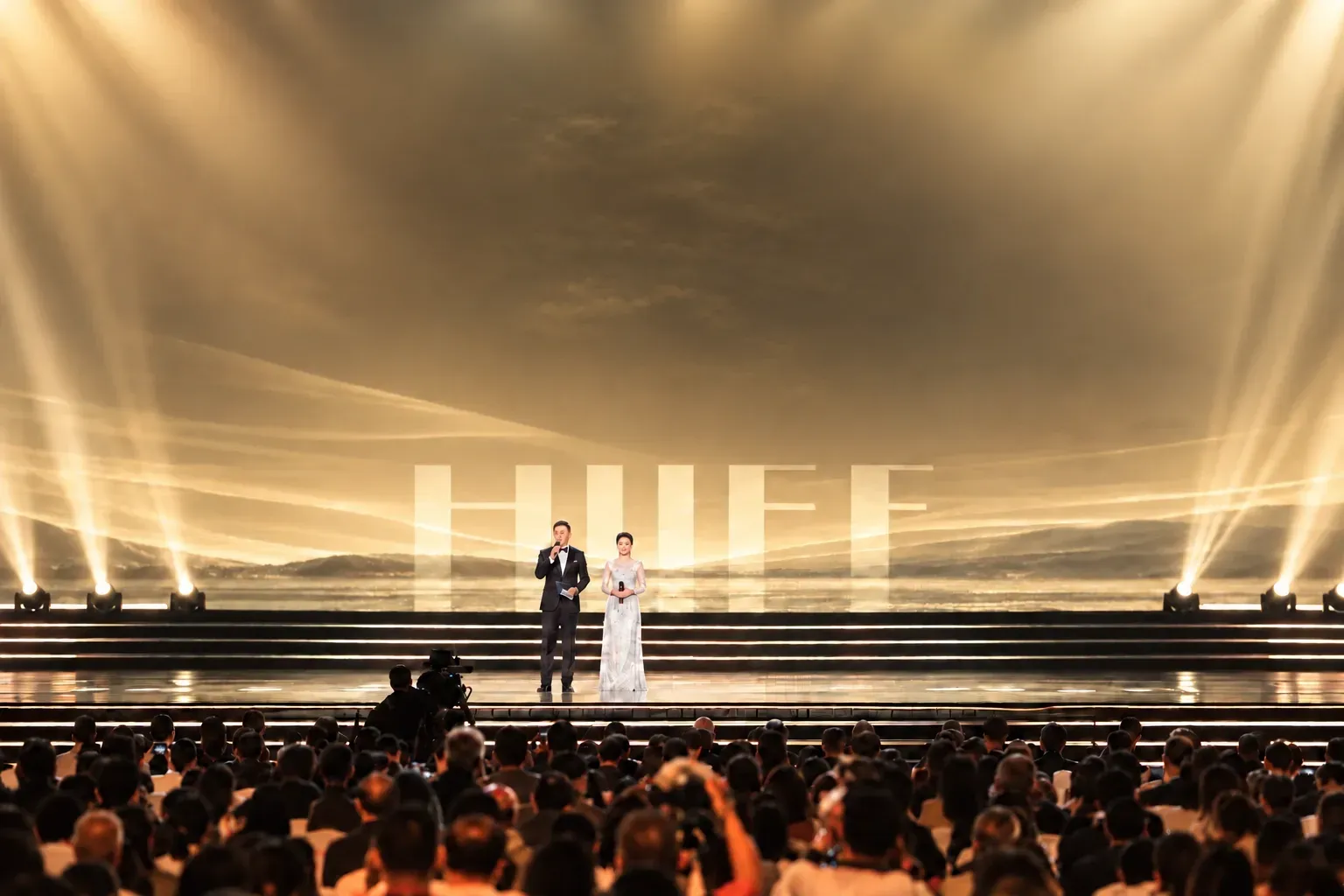 暖黄典礼舞台、平面 HIIFF 屏幕、主持人与观众